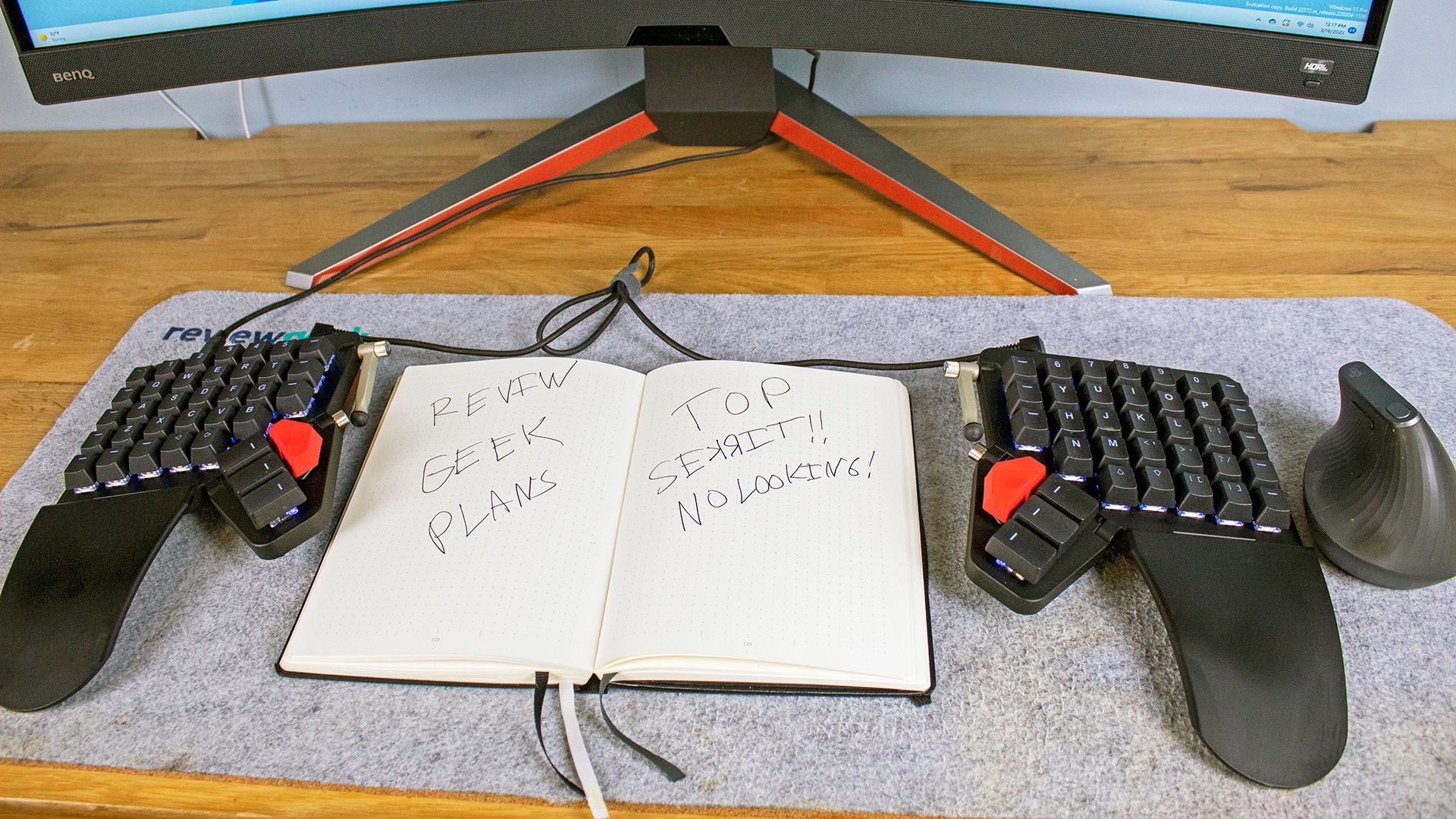 A Moonlander keyboard with a bullet journal between the halves