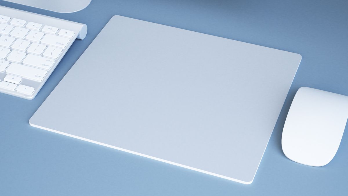 A modern white computer mousepad next to a mouse and keyboard.
