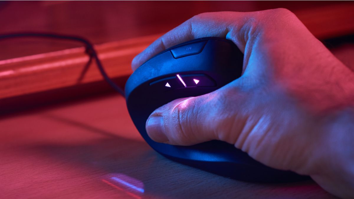 Closeup of a person's hand on an ergonomic mouse under RGB lighting.