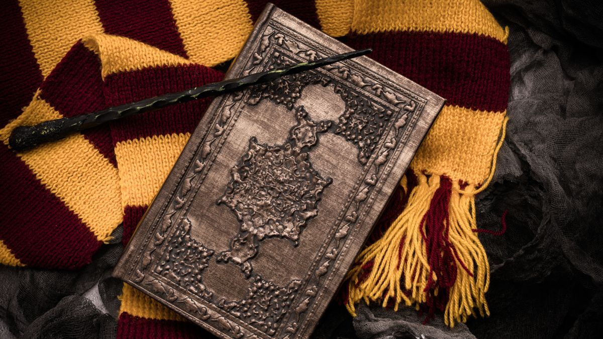 A collection of Harry Potter-type memorabilia, including a wand, book, and scarf.