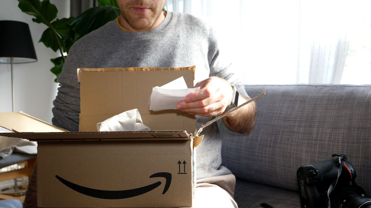 Man opening an Amazon package and reading the order slip.