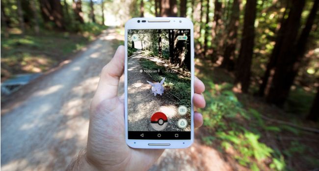 A smartphone showing the Pokemon Go mobile game in an outdoor setting.