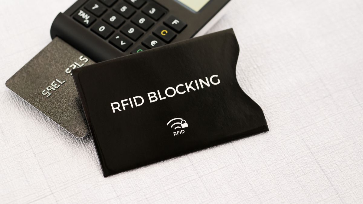 An RFID-blocking sleeve with a credit card in a card reader behind it.