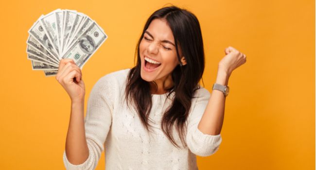 A woman with an excited expression holding a fan of one-hundred dollar bills.