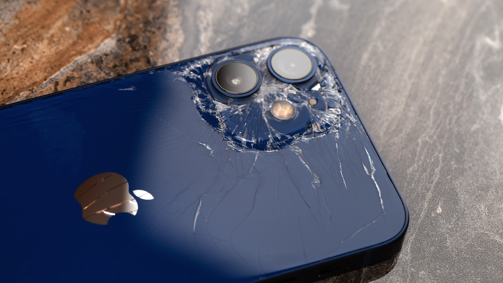 An iPhone with broken back glass.