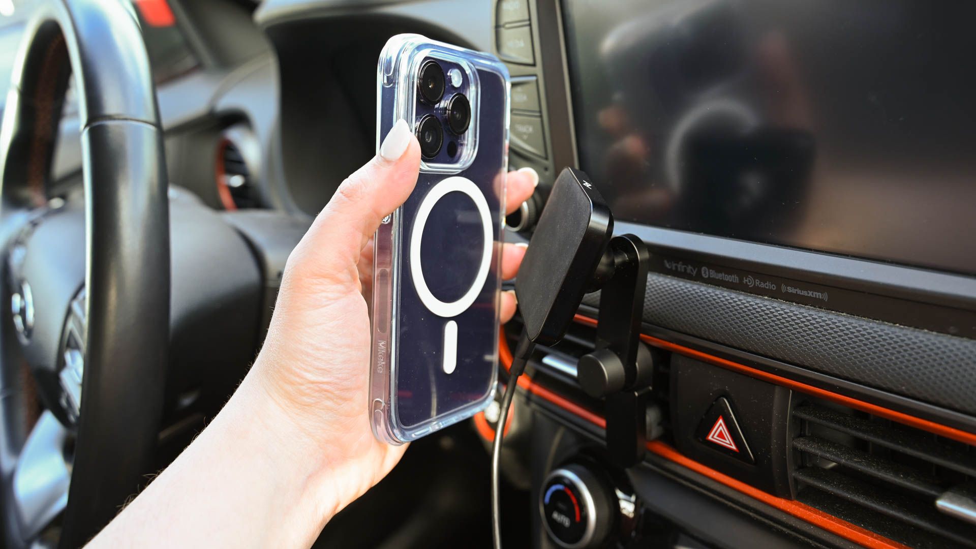 Person placing an iPhone 14 on the Peak Design Wireless Charging Vent Mount