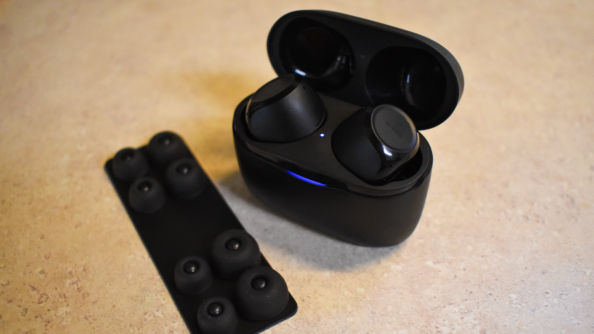 Wyze Buds on a table with the four extra pairs of eartips.