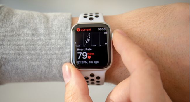 Person's hand checking heart rate on an Apple Watch.