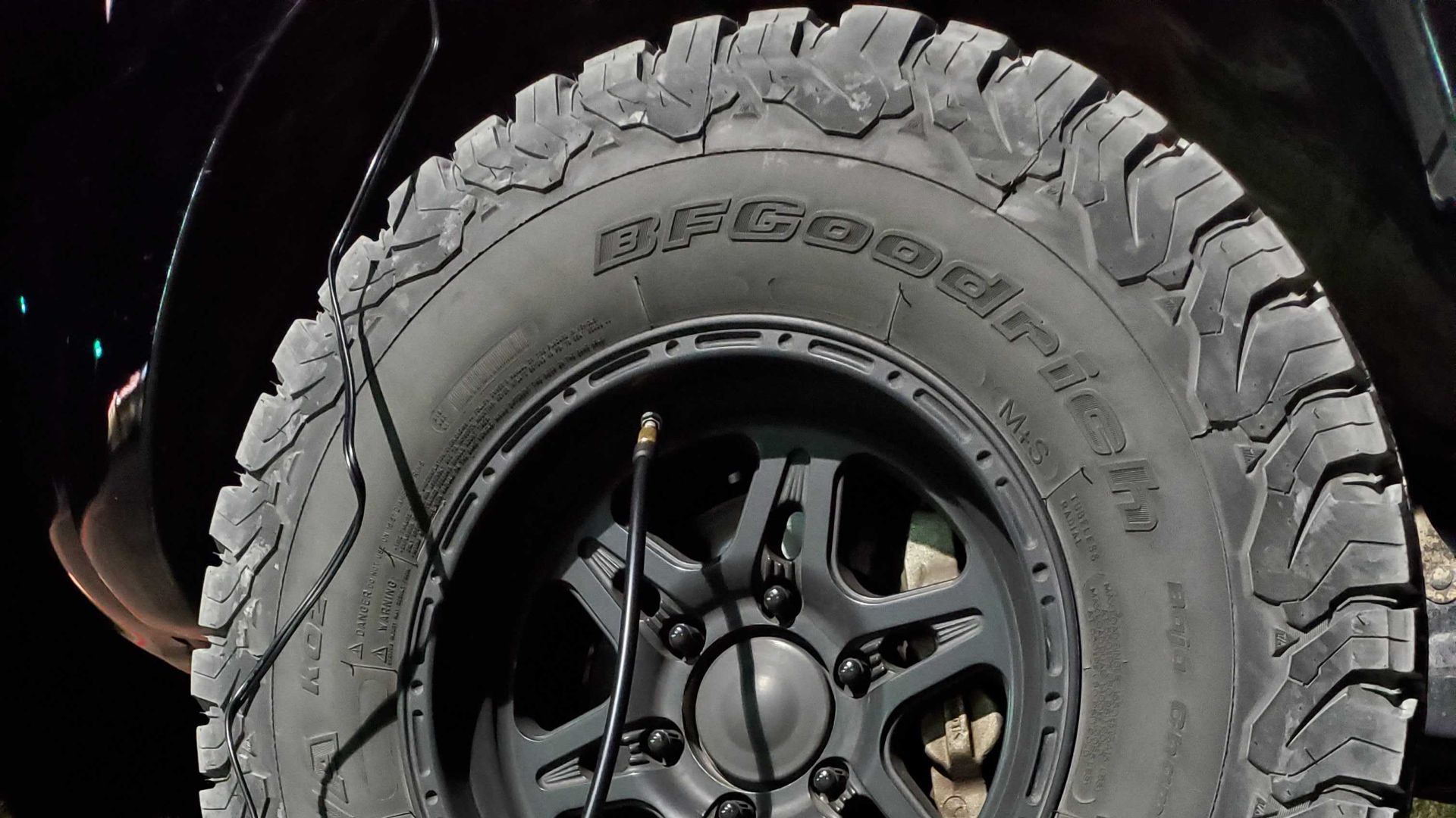 adding air to a car tire