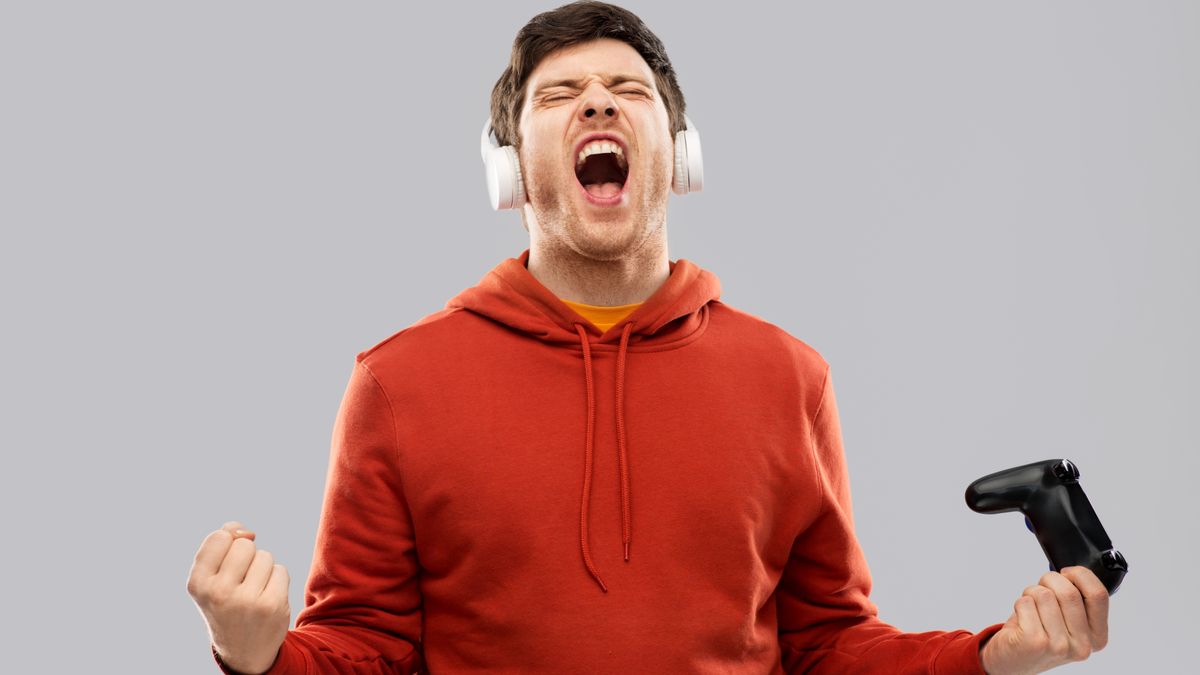 A gamer holding a controller and shouting in victory.