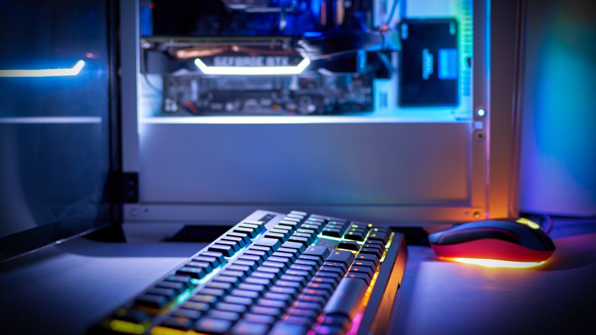 RGB-lit keyboard with an illuminated PC tower in the background.