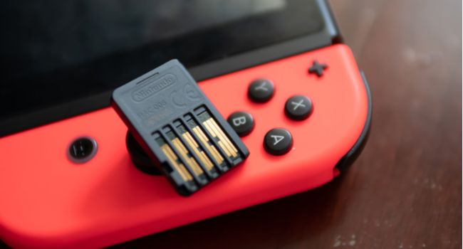 Closeup of a Nintendo Switch game cartridge on top of a Switch unit.