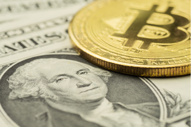 A Bitcoin token and a dollar bill.