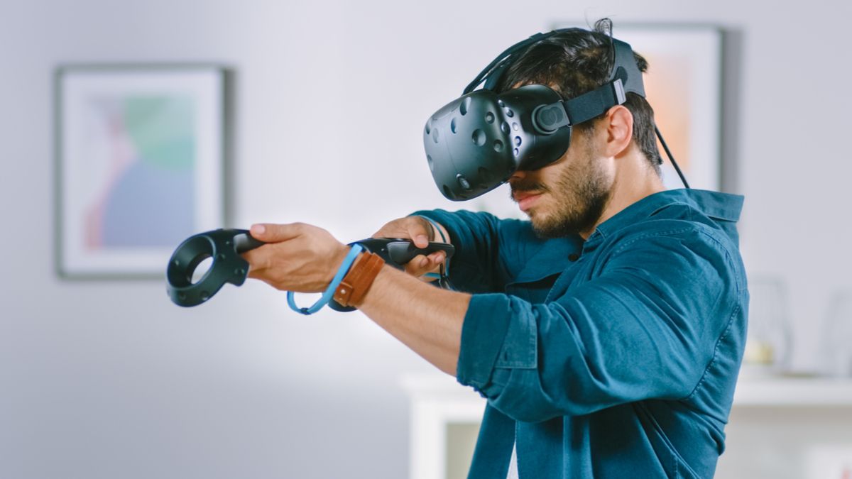 A man wearing a VR headset and aiming with controllers.