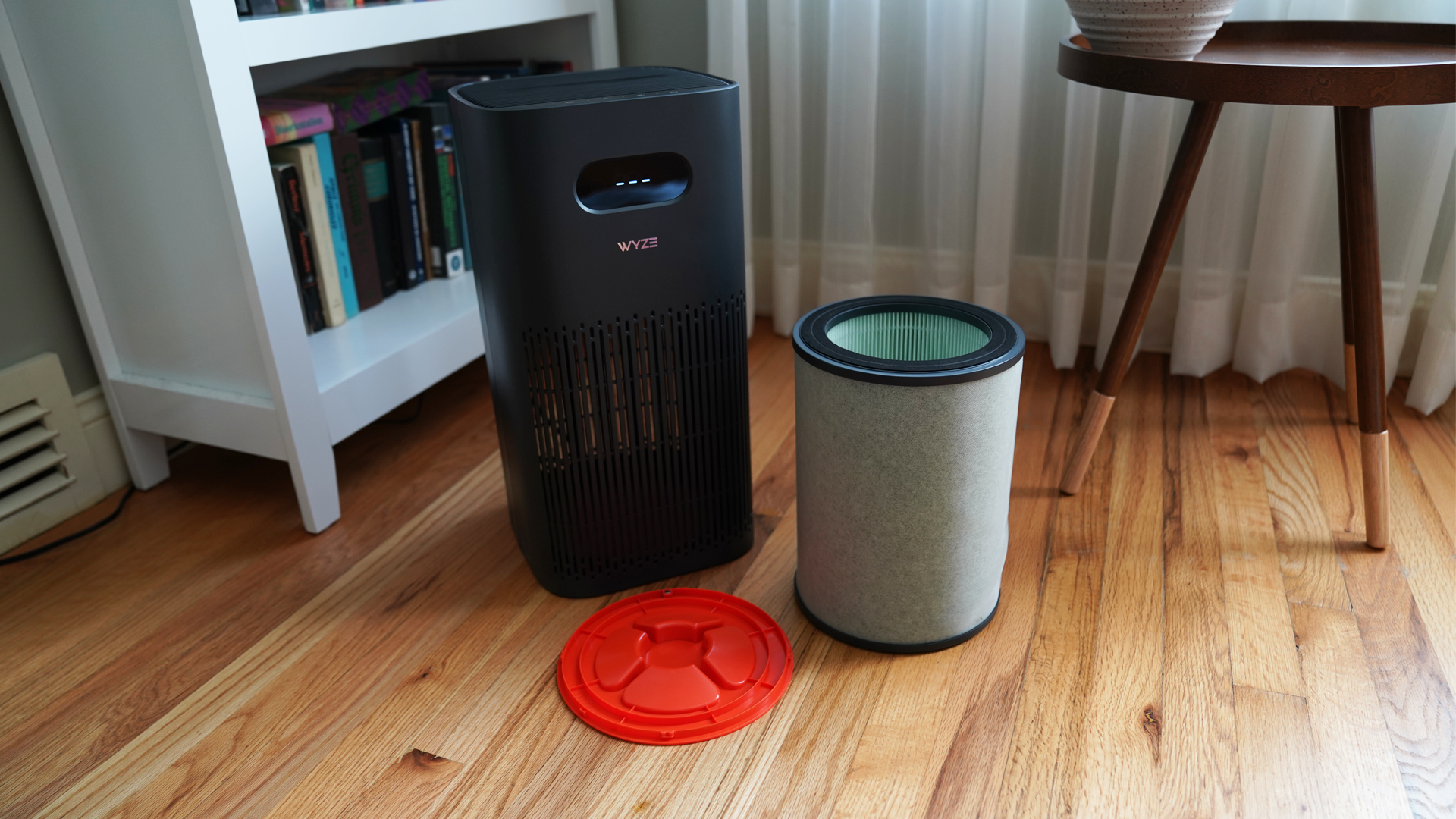 The Wyze Air Purifier next to its Allergen filter and filter compartment seal in a bright living room..
