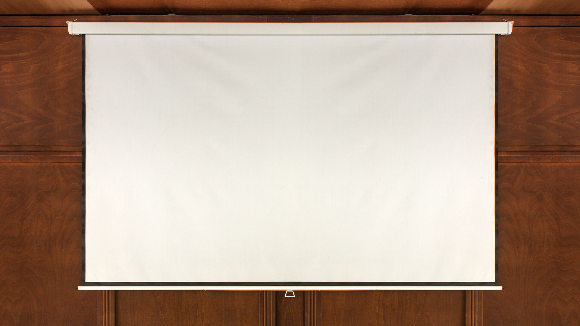 A projector screen over a woodgrain wall.