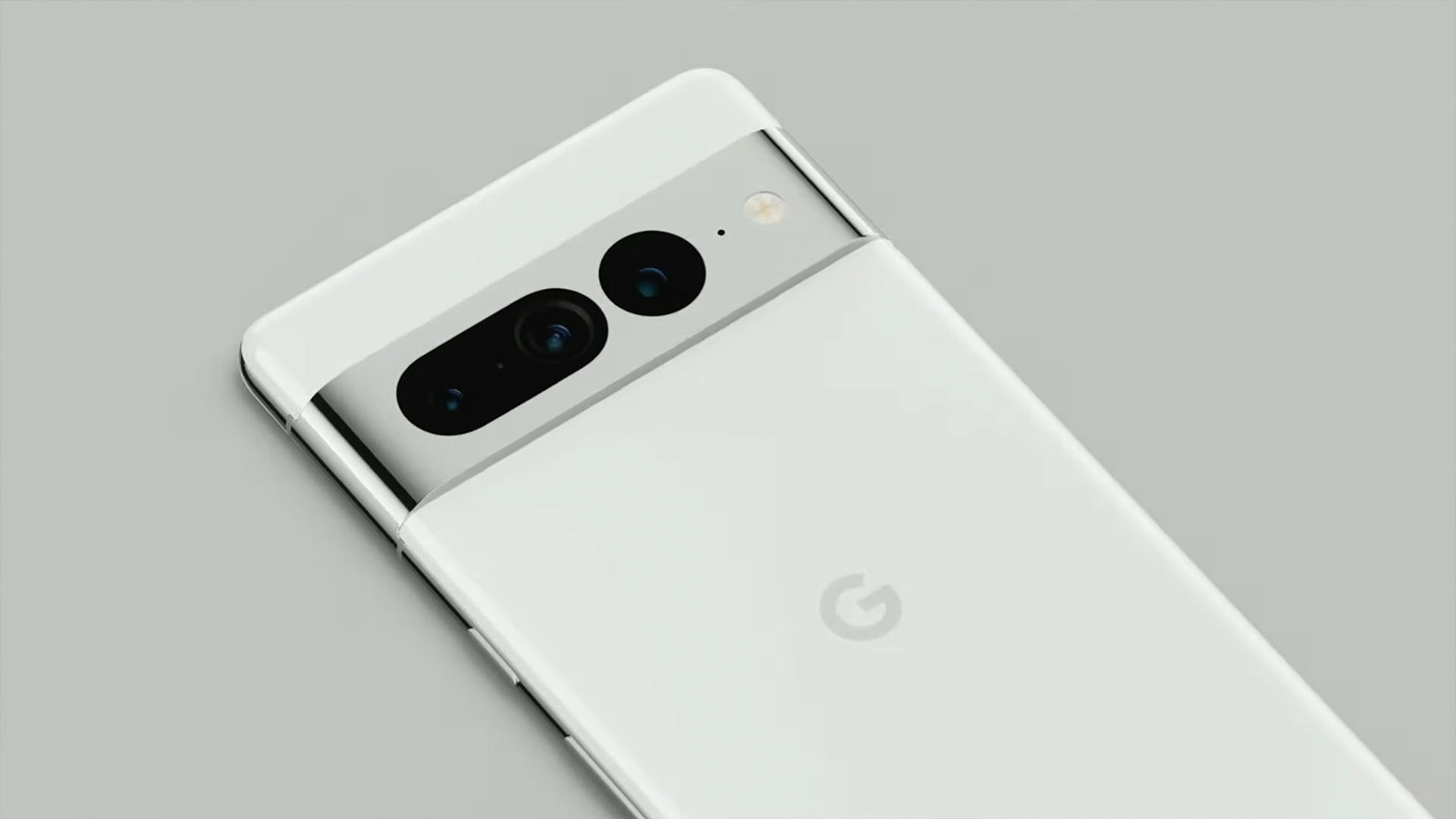 The Google Pixel 7 in white. Its camera bar features two large back lenses, one of which is oval shaped.