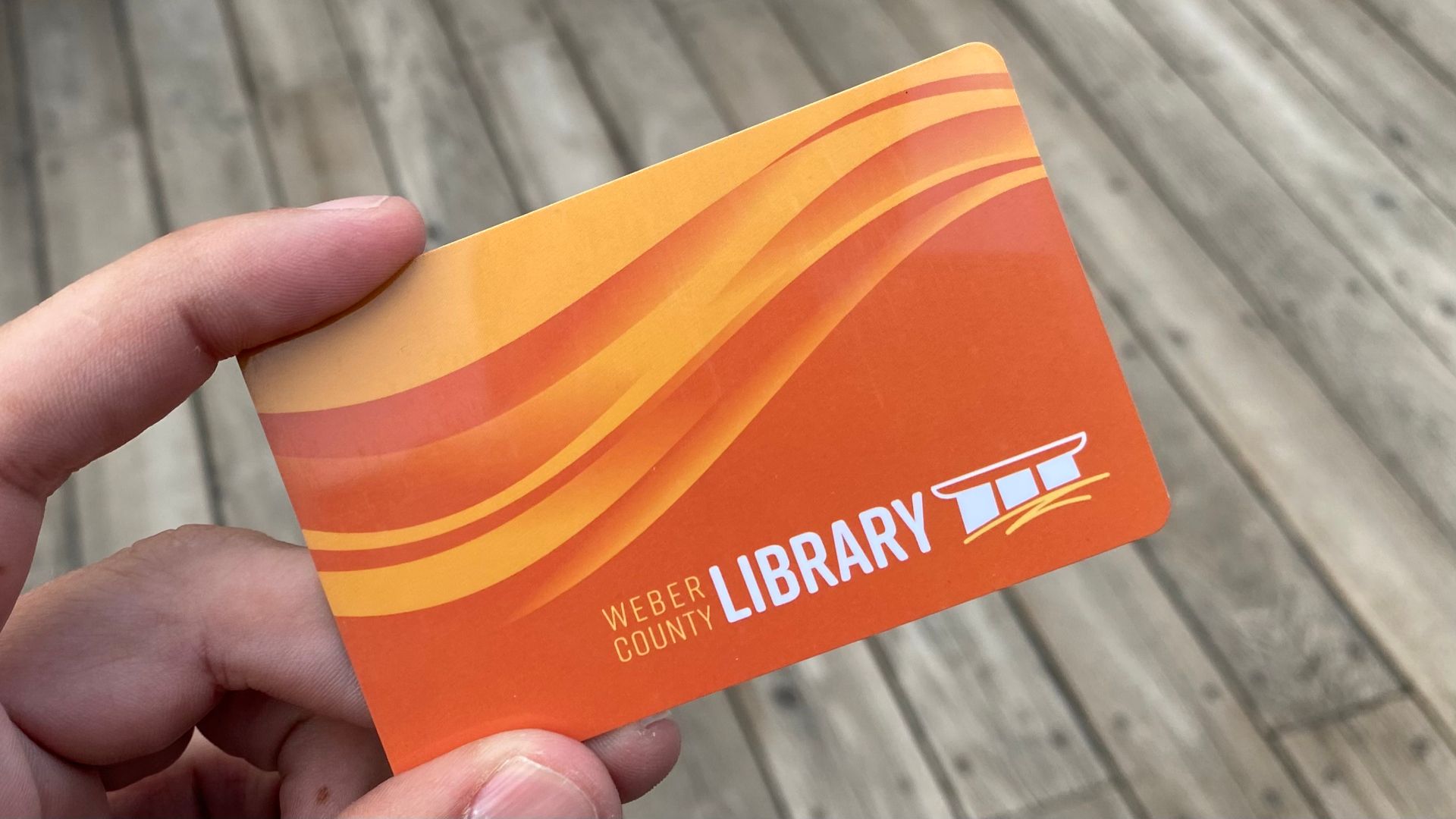 Man holding an orange library card.