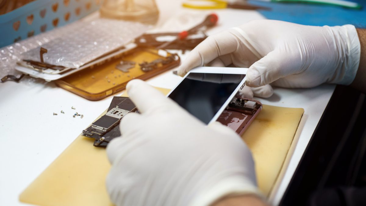 An iPhone being disassembled by a technician.