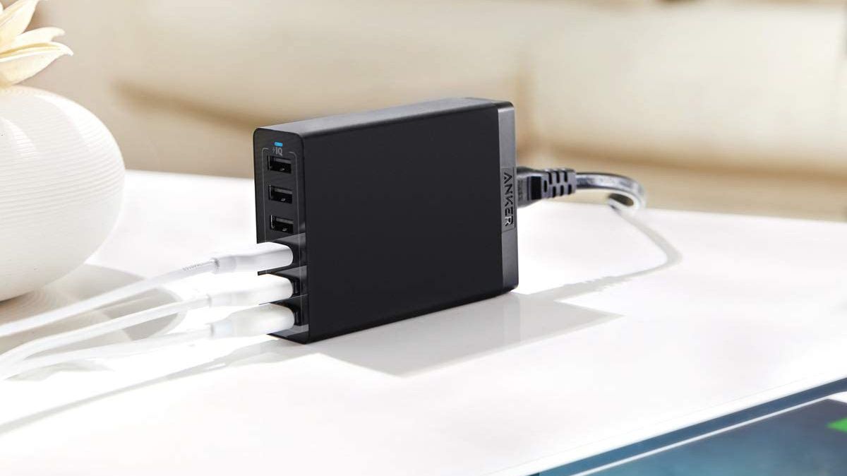 Anker 60W 6-Port USB Wall Charger sitting on desk with three cables plugged in