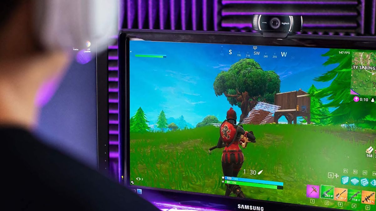 Logitech C922x Pro Stream Webcam mounted on a Samsung monitor while a gamer plays Fortnite