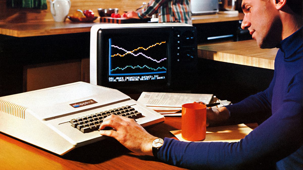 A man using an Apple II in a kitchen, 1970s, from a vintage Apple II advertisement.