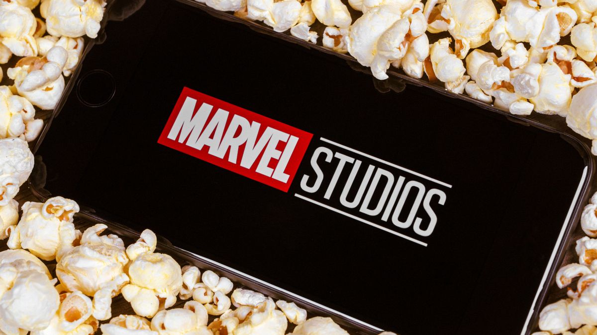 A smartphone surrounded by popcorn and showing the Marvel Studios logo.