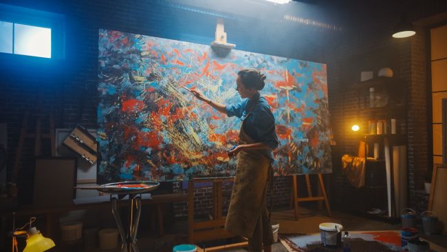 An artist creating an abstract painting.