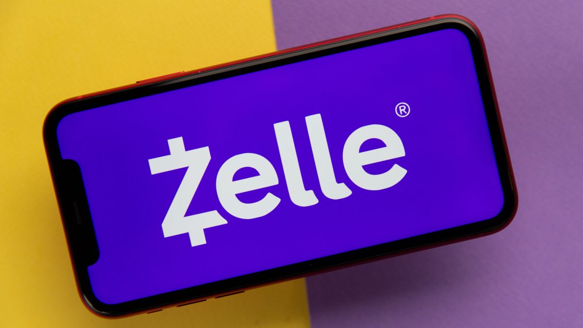 Zelle logo on an iPhone display against a yellow and purple background.
