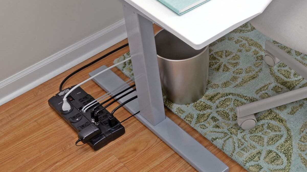 A Tripp Lite surge protector in use beneath a desk. 