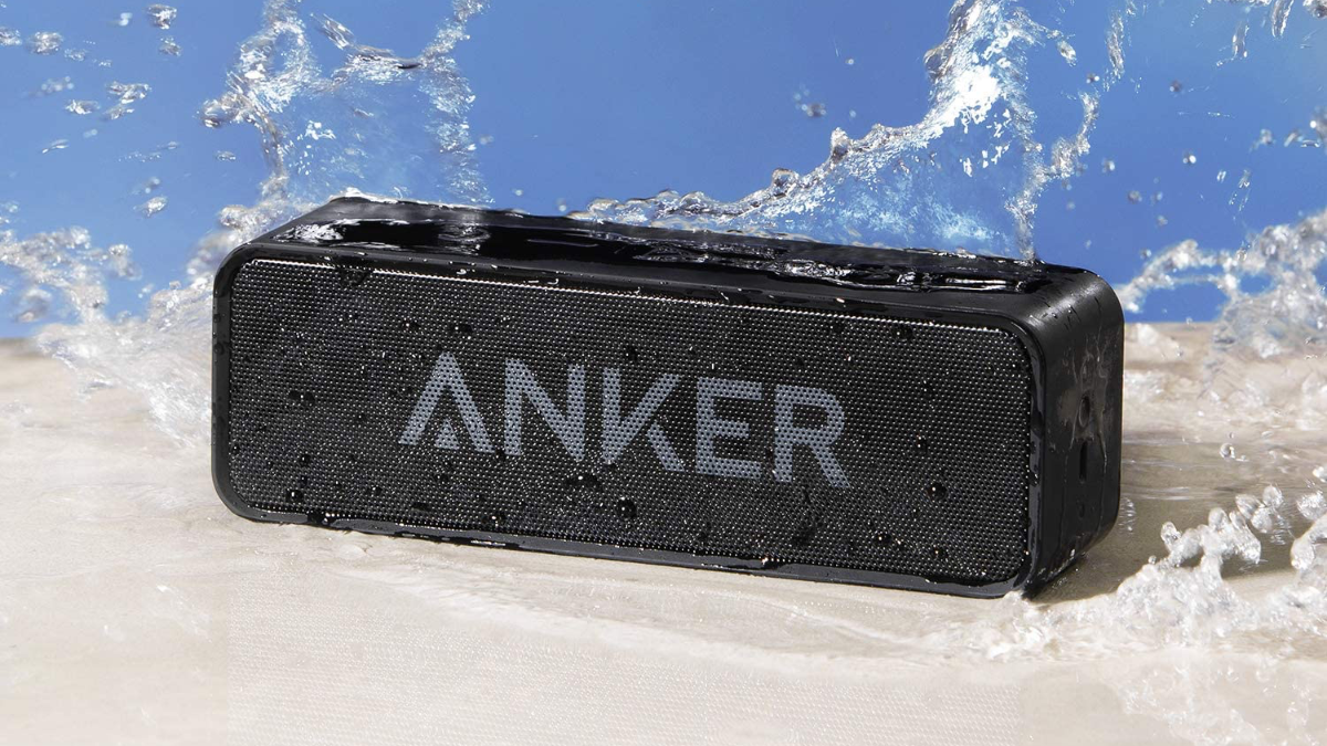 Anker Soundcore Bluetooth Speaker drenched in water on a sandy beach