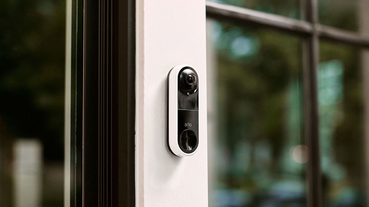 An Arlo doorbell installed beside a glass front door.