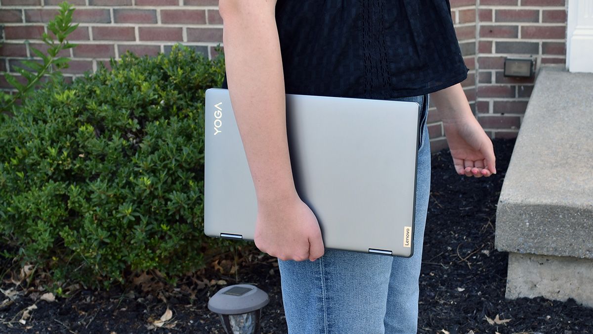 Closed Lenovo Yoga 7i laptop held by a girl