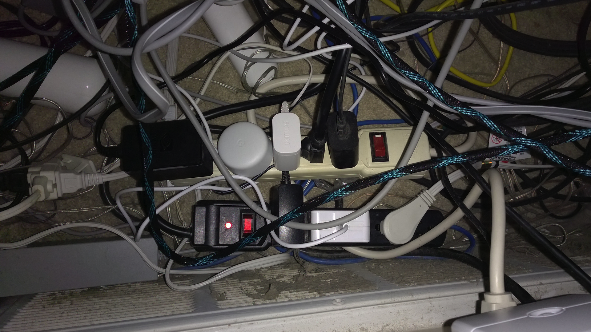 The worst mess of surge protectors and dust you've ever seen.