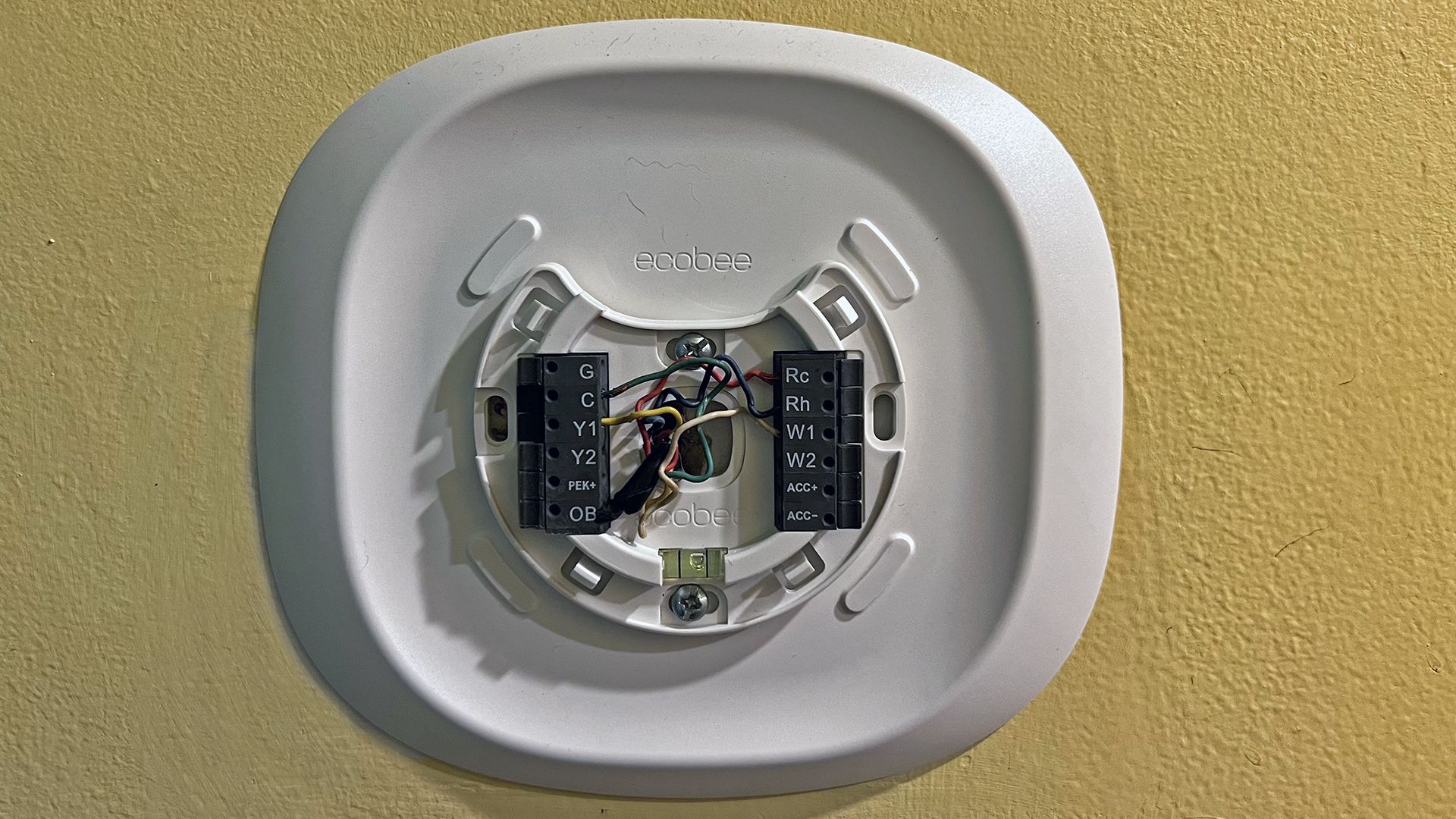 An ecobee mounting plate with wiring showing