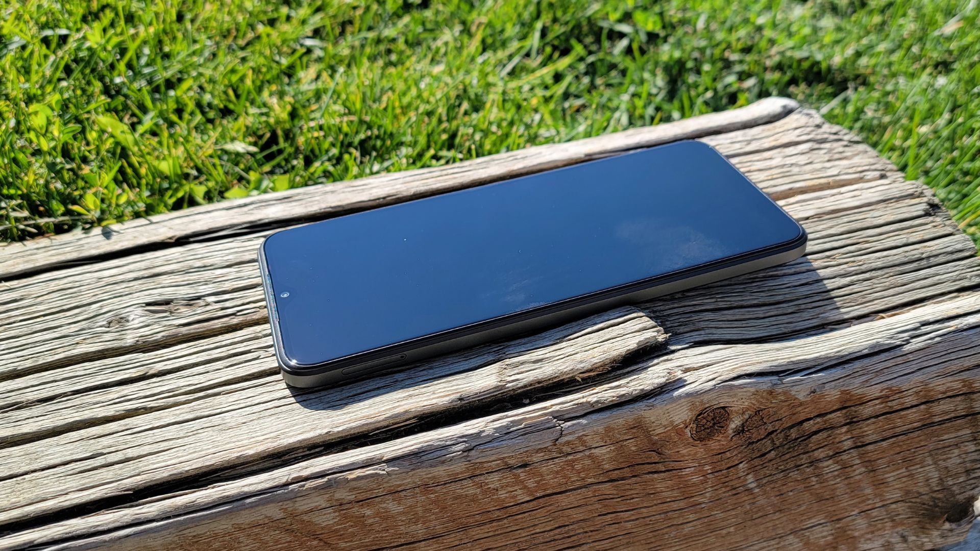 closeup of the display on the tmobile revvl 6 pro smartphone, on a wooden log