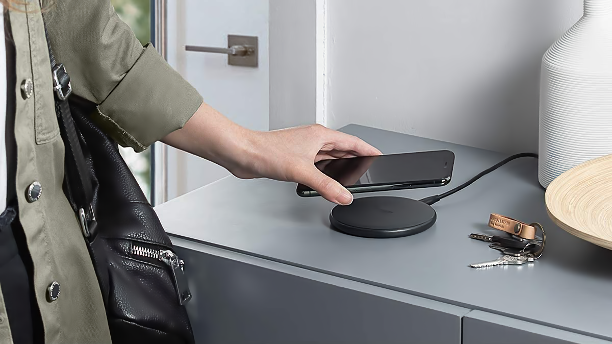 Person putting phone down onto an Anker Wireless Charger