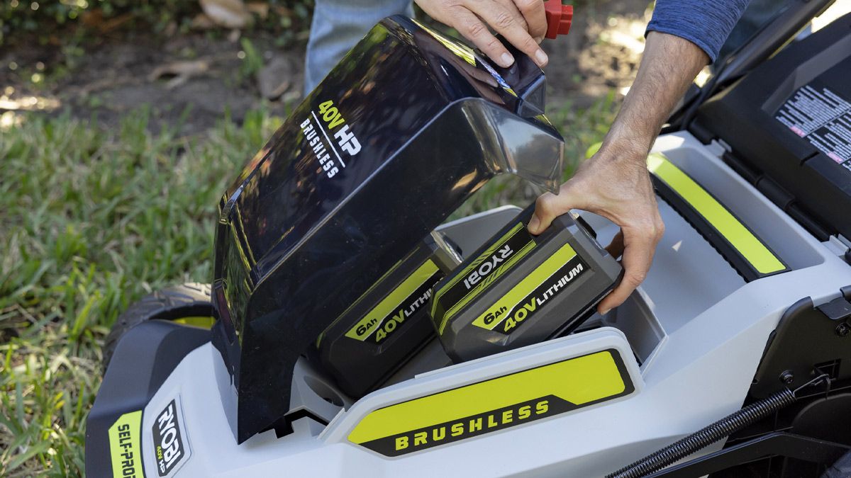 A person loading lithium-ion batteries in their lawn mower.