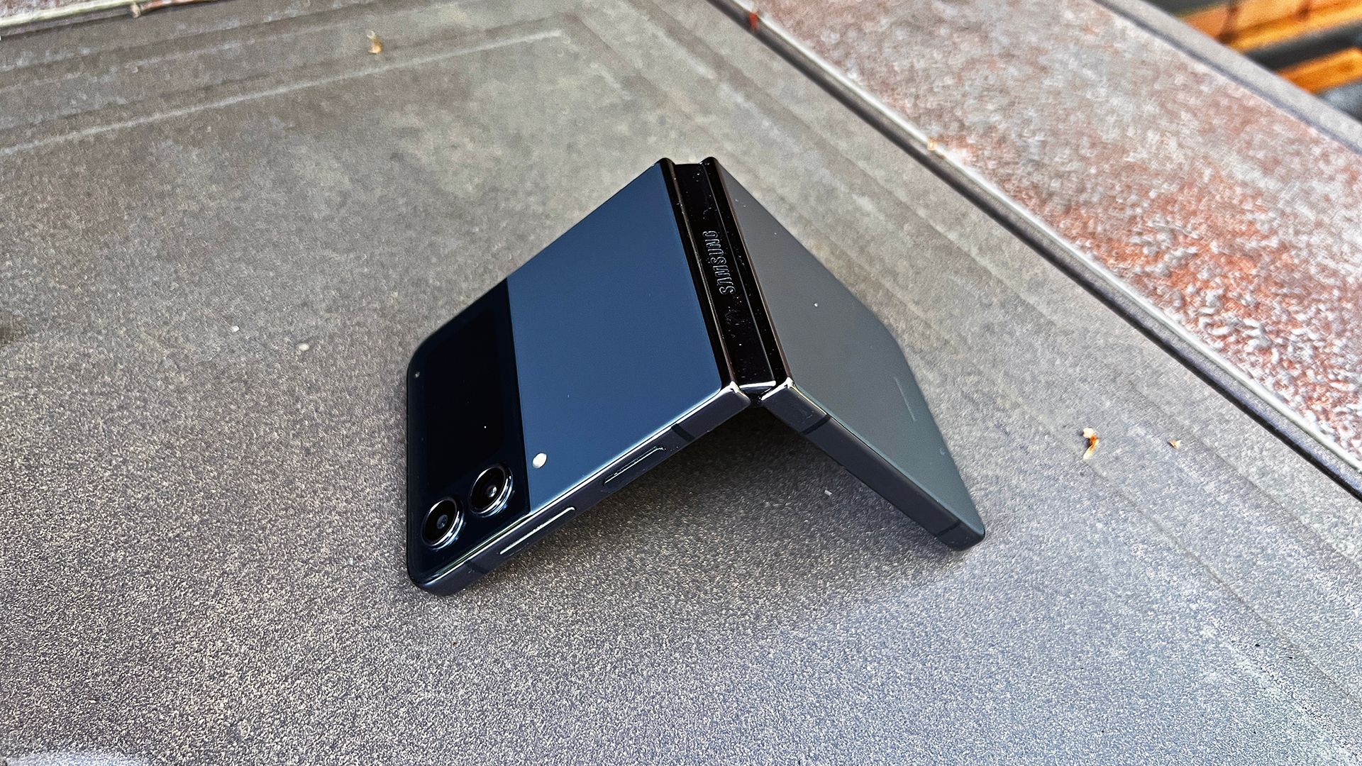A Samsung Galaxy Z Flip 4 open in tent position on a firepit
