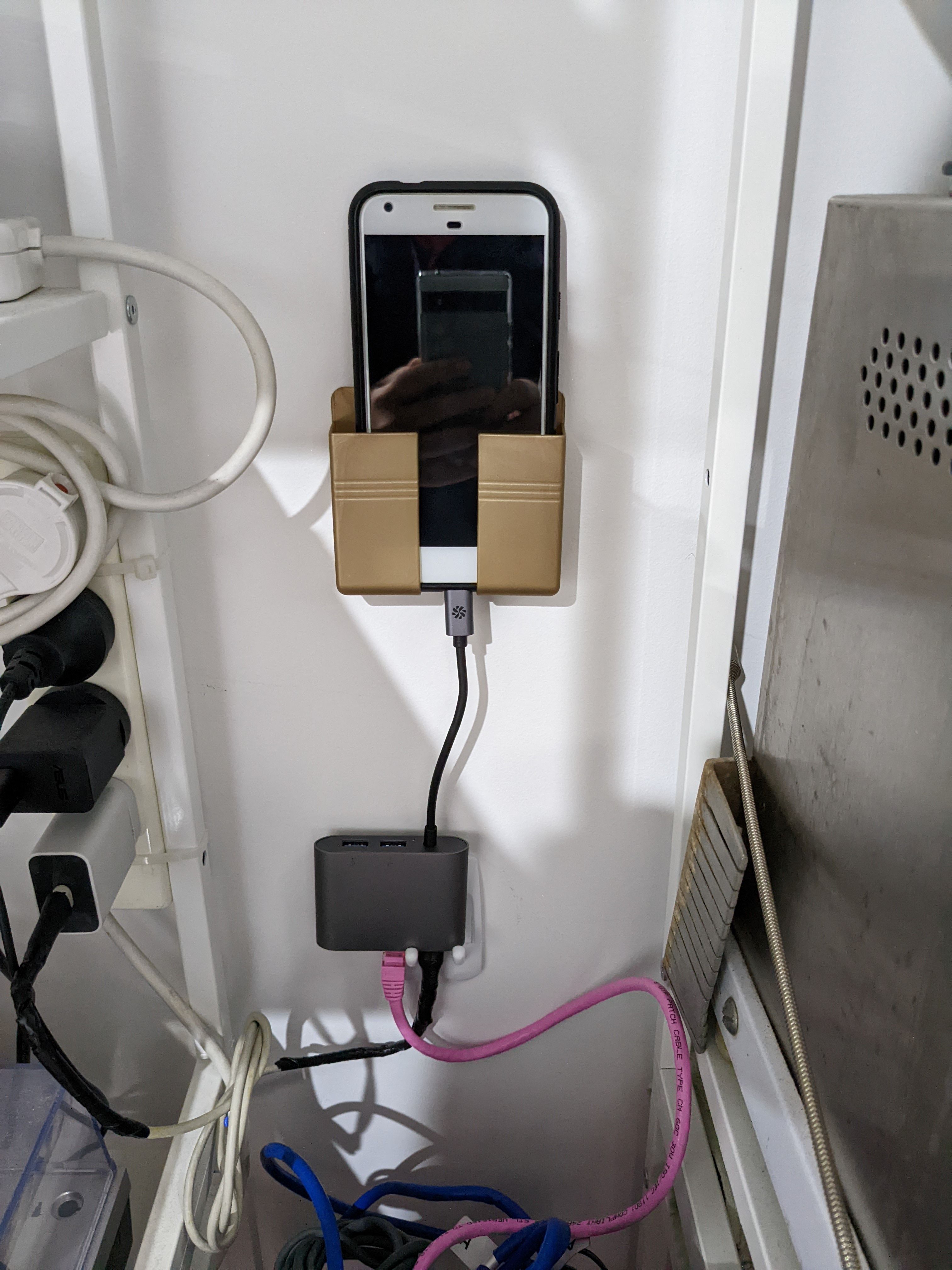 Photo of a Pixel phone in a closet, connected to a USB hub