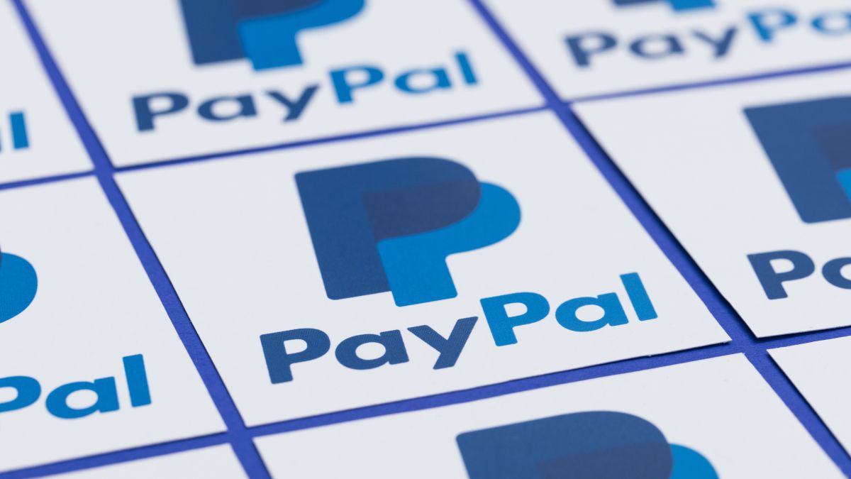 Several printed paper copies of the PayPal logo arranged in a grid.