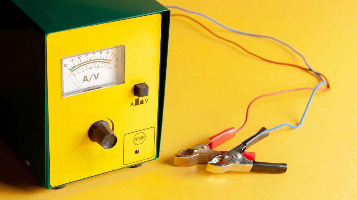 A portable car battery recharger on a yellow background.