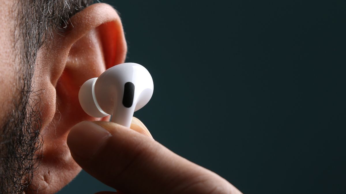 Closeup of an Apple AirPod being placed in a person's ear.