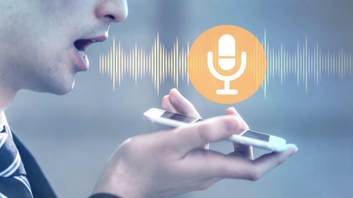 Man speaking to a smartphone with soundwaves coming from his mouth and a microphone icon above the phone.