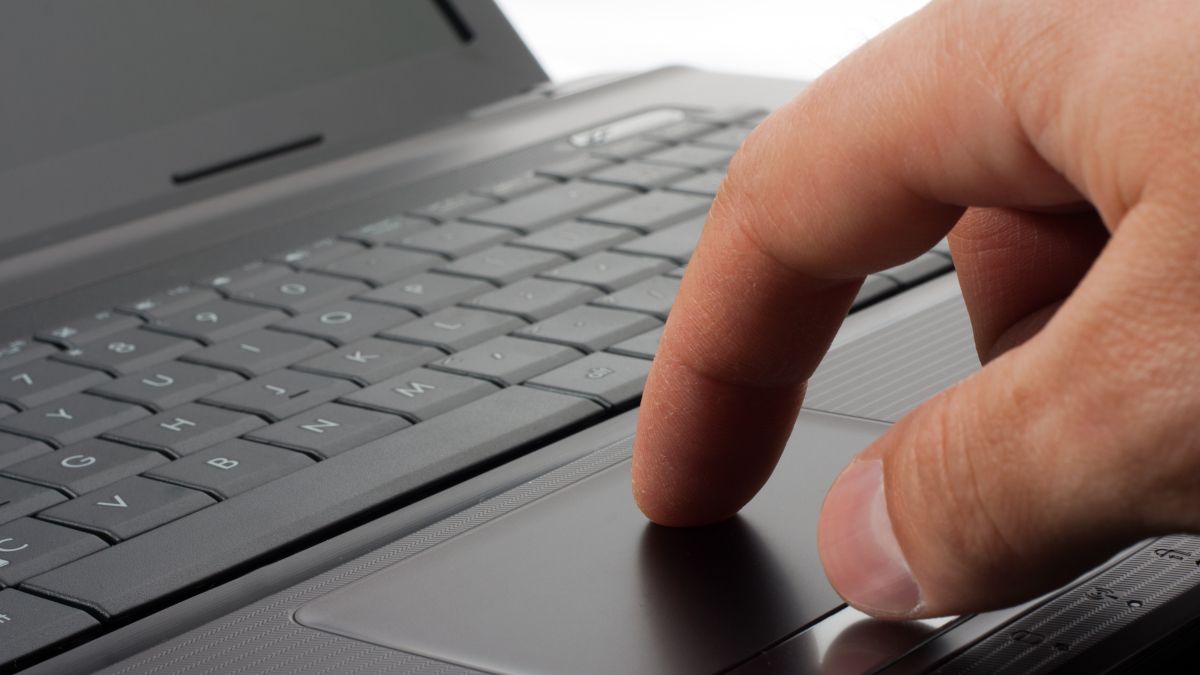 Person's finger on a laptop's touchpad.