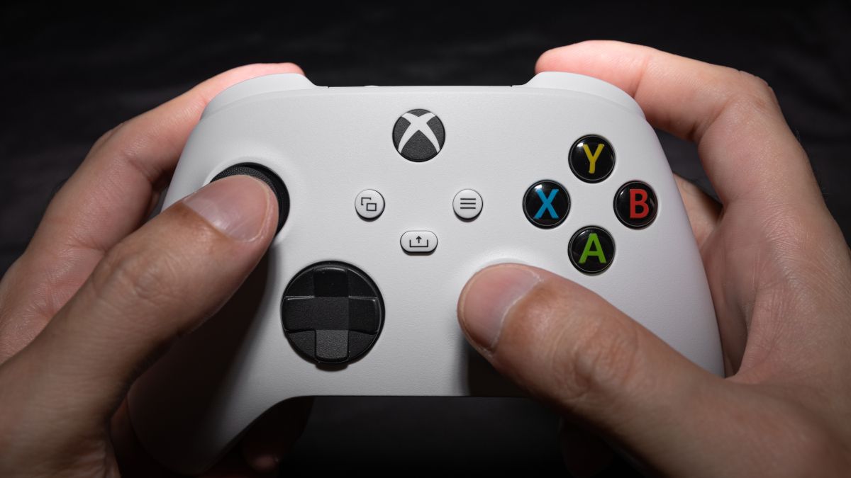 A white Xbox Series S controller being held in a person's hands.