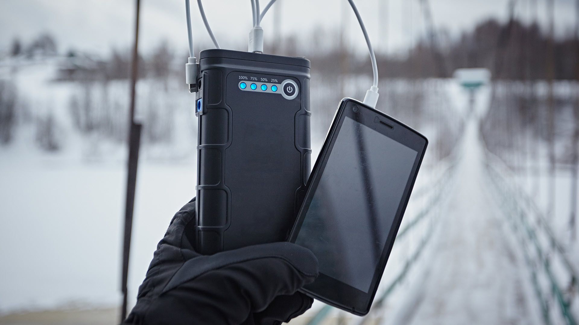 A portable battery struggling to charge a phone in the snow