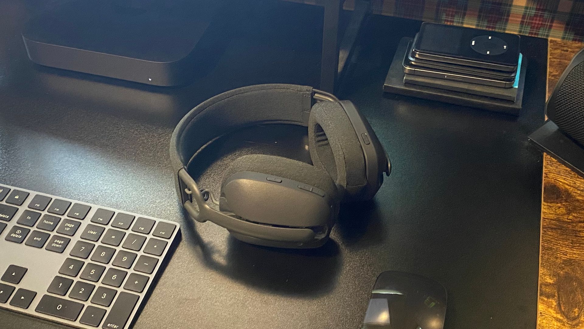 Zone Vibe 100 headphones sitting on a desk next to a Magic Keyboard, Magic Mouse, and Mac mini