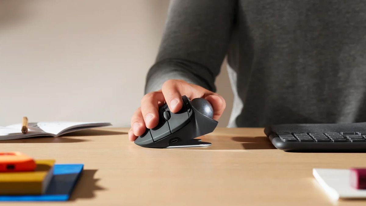A person using a Logitech Ergo MX trackball mouse.