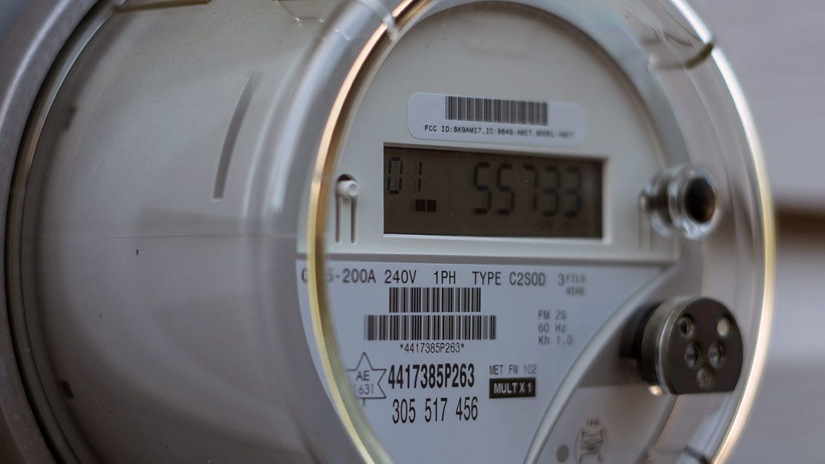 A closeup view of a smart power meter attached to a residence.